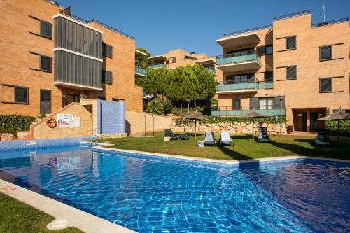 a swimming pool with several people in it at Pierre & Vacances Salou in Salou