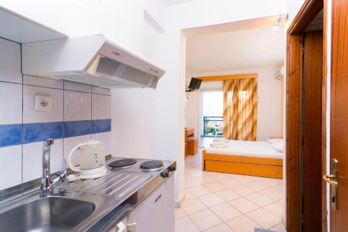 een keuken met een wastafel en een slaapkamer met een bed bij Studios Maria in Potos