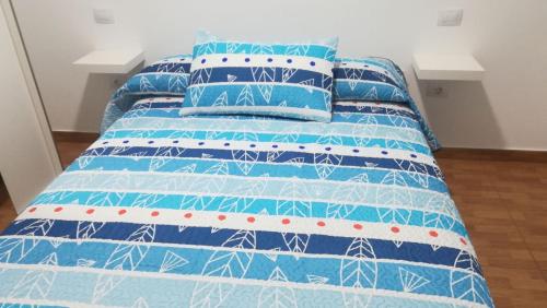 アリナガにあるApartamento Quintanaの青いベッド(青と白のシーツ、枕付)