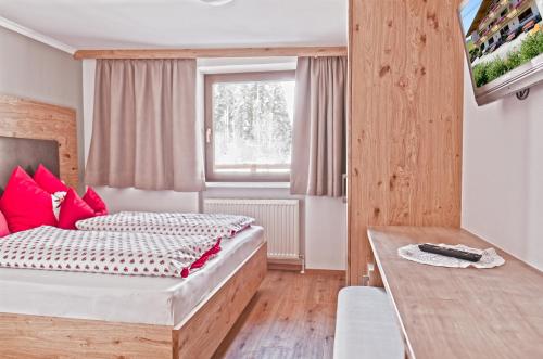 ein Hotelzimmer mit einem Bett und einem Fenster in der Unterkunft Pension Aloisia in Scheffau am Wilden Kaiser