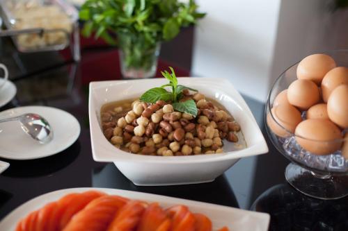 a bowl of beans and eggs and carrots on a table at Aleph Boutique Hotel in Jbeil