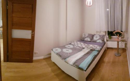 małą sypialnię z łóżkiem i drzwiami w obiekcie Apartament Jelen'iowska w Kielcach