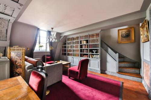 - un salon avec un escalier et des chaises rouges dans l'établissement Parc Royal Appartements, à Paris