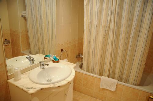 La salle de bains est pourvue d'un lavabo et d'une douche. dans l'établissement Hotel Arnal, à Escalona