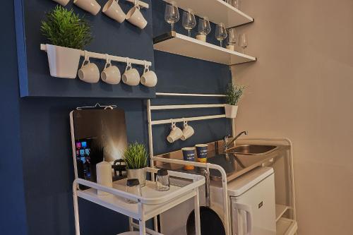 a kitchen with a sink and a shelf with pots and pans at ONYX Apartment in Budapest