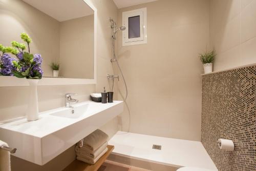a white bathroom with a sink and a shower at Bcngotic in Barcelona