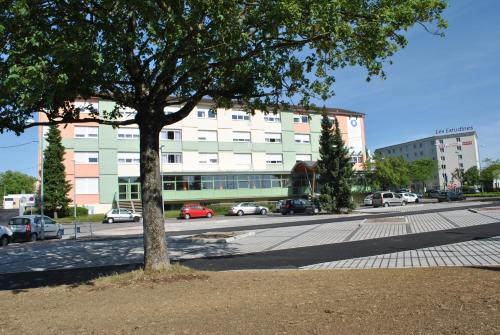 a large white building with cars parked in front of it at ETHIC ETAPES DIJON Accueil 24h24 et parking gratuit in Dijon