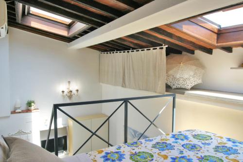 フィレンツェにあるConce Studio in Santa Croceの天窓付きのベッドルーム1室、ベッド1台が備わります。
