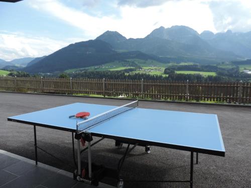 a ping pong table with a ping paddle on it at Apartmenthaus Vergissmeinnicht in Abtenau