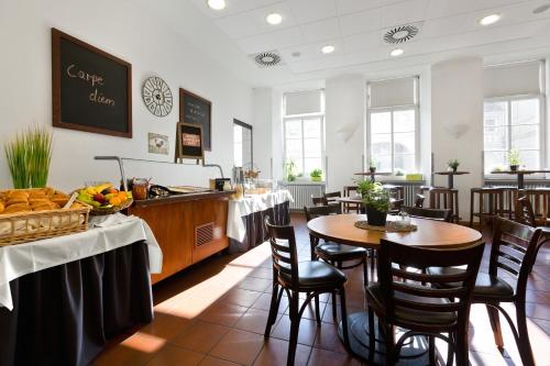 特里尔Kolping Hostel Trier im Warsberger Hof的餐厅里有桌椅的餐厅