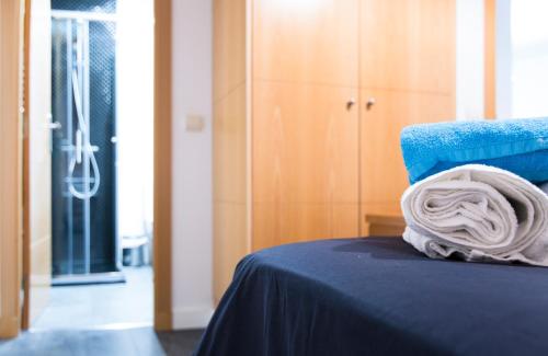 a pile of towels sitting on top of a bed at Huertas- El corazón de Madrid in Madrid