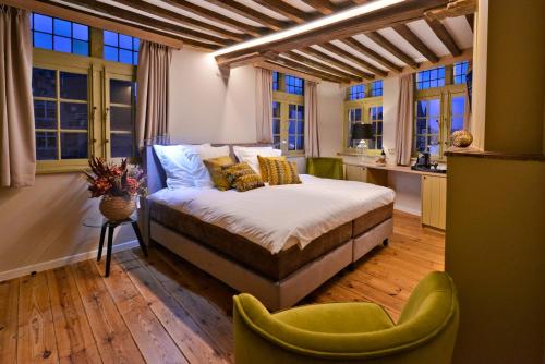 ein Schlafzimmer mit einem Bett in einem Zimmer mit Fenstern in der Unterkunft Rooms With A View in Gent
