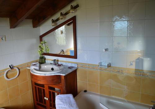 W łazience znajduje się umywalka, wanna i lustro. w obiekcie Posada El Valle - Adults Only w mieście Suances