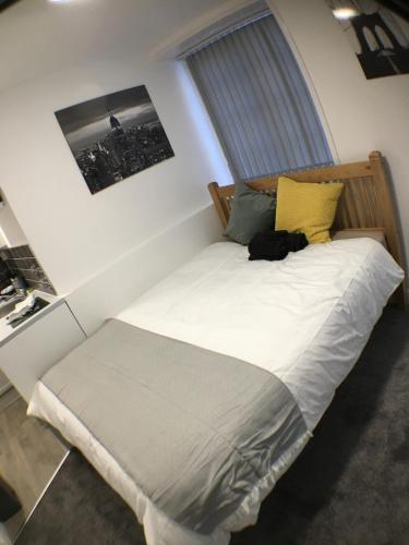 sypialnia z białym łóżkiem i żółtą poduszką w obiekcie Castle Terrace (B3 R4) w mieście Dudley