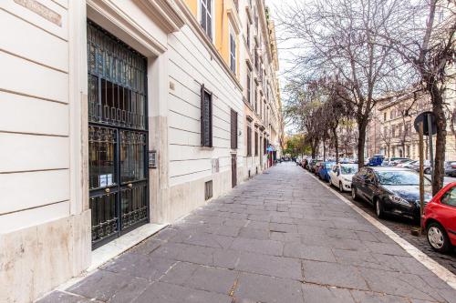 eine Straße mit Autos, die an der Seite eines Gebäudes geparkt sind in der Unterkunft Time in Rom