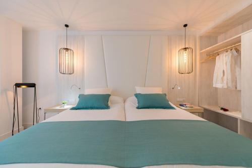 a bedroom with a large bed with two blue pillows at HC Luxe in Vecindario