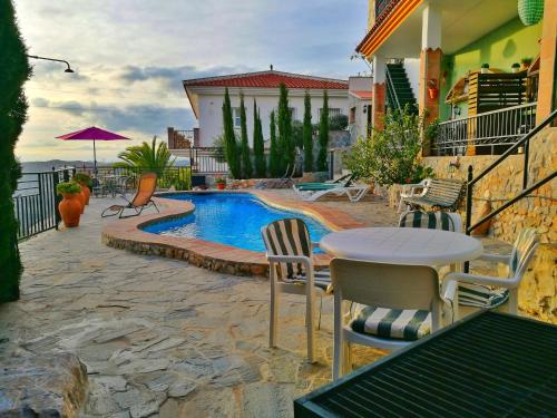 a patio with a table and chairs next to a pool at Apartamentos Alma y Montaña in Cómpeta