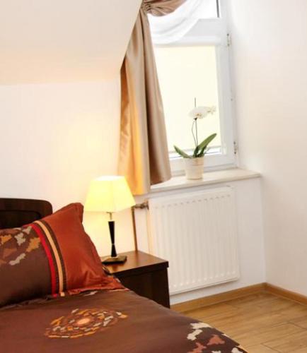 a bedroom with a bed and a window and a lamp at Wodnik in Krosno