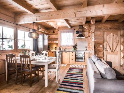 een keuken en eetkamer met een tafel en een bank bij TatryTop Domek pod Giewontem in Zakopane