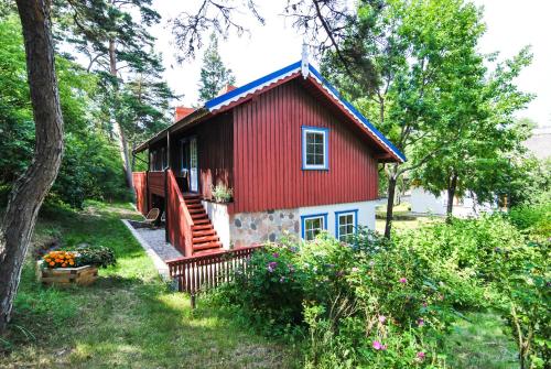 a red cottage with a red roof at Apartamentai Gėlių Vila in Nida