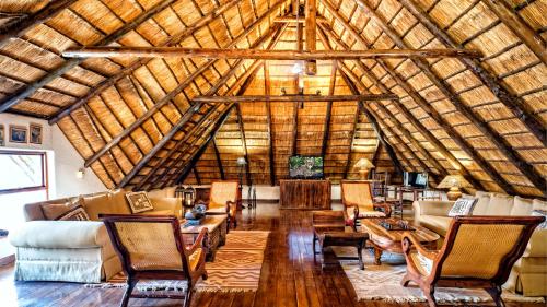 a large living room with a wooden ceiling at Nyati Safari Lodge in Hoedspruit
