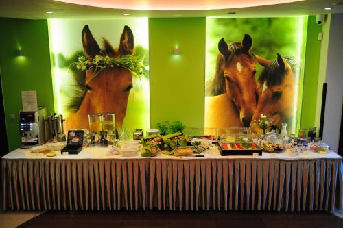 een tafel met eten erop en paarden op de muur bij Klimatyczne Domki - Całoroczne in Radomsko