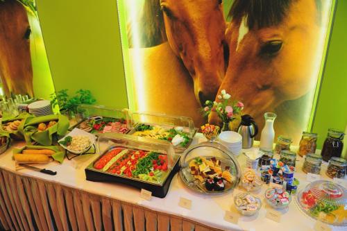 een tafel met een buffet en een paard bij Klimatyczne Domki - Całoroczne in Radomsko