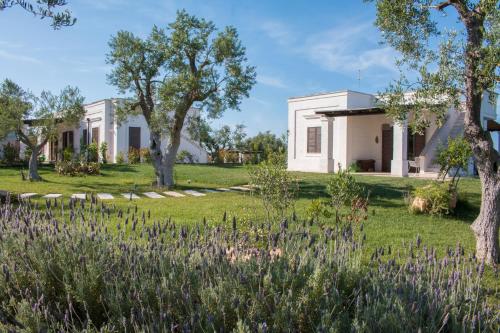 a garden with purple flowers in front of a white house at Villa del Vento in Polignano a Mare