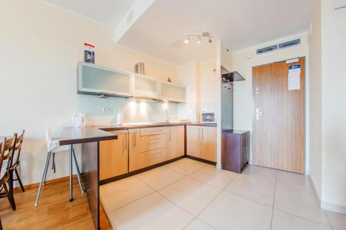 a kitchen with wooden cabinets and a counter top at Olympic Park I, Sun & Snow in Kołobrzeg