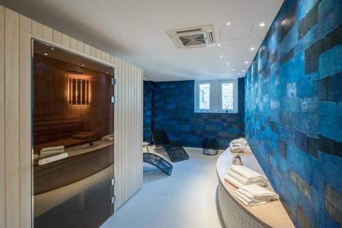 Baño con azulejos azules en la pared en Mercure Mulhouse Centre, en Mulhouse