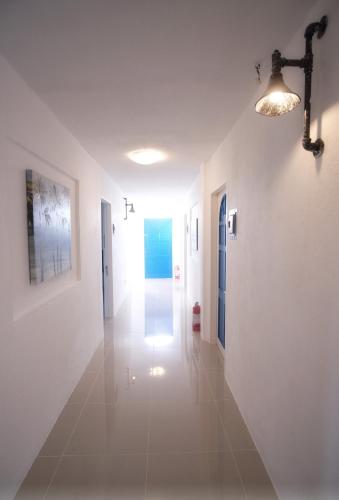 a hallway with white walls and a light fixture at D´Gecko Hotel in Moalboal