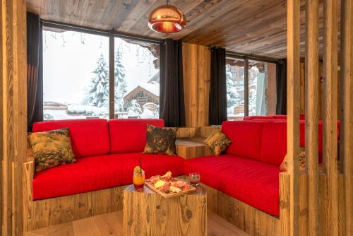 a living room with a red couch and a table at Hotel Eterlou in Méribel