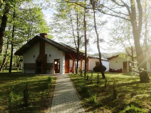 a house in the middle of a field with trees at Domki Cztery Pory Roku in Czchów