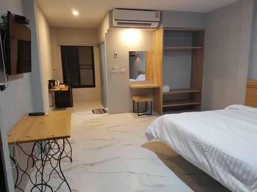Un dormitorio con una cama y un escritorio en una habitación. en DD Garden Home, en Phayao