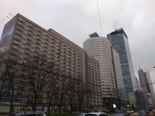 a large building with cars parked in a city at Apartment Oscar in Warsaw