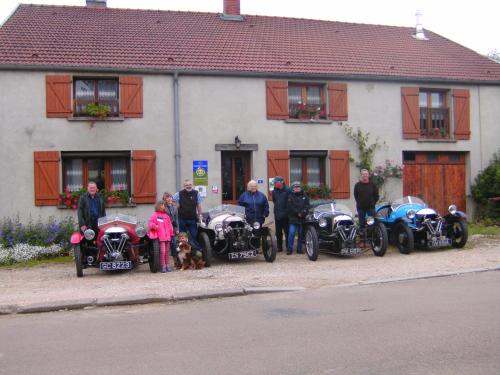 a group of people standing in front of a house with motorcycles at A la source du saolon in Culmont