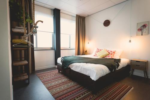 
a bedroom with a large bed and a large window at Hotel Nimma in Nijmegen

