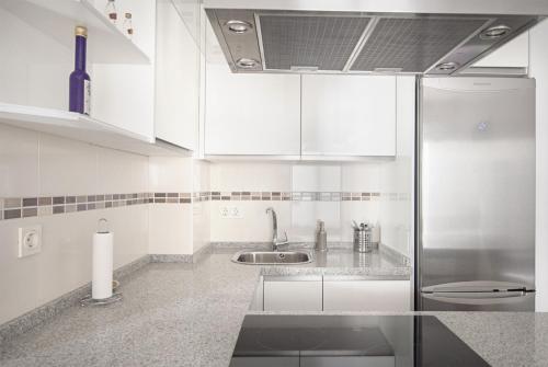 フエンヒロラにあるCubo's Apartamento Espana Fuengirola 2Bの白いキッチン(シンク、冷蔵庫付)