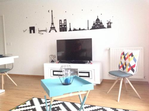 a living room with a tv and a table and chairs at SouheilRebekaHome in Serris