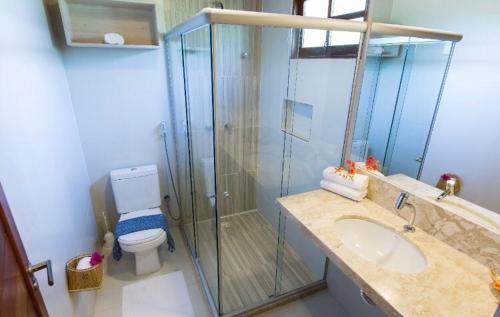 een badkamer met een douche, een wastafel en een toilet bij Pousada Porto Manguaba in Japaratinga