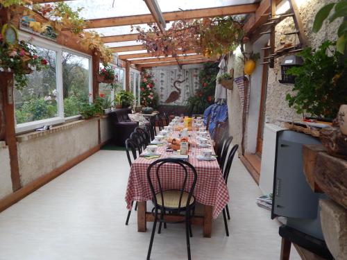 een lange tafel in een patio met een tafelkleed bij A la source du saolon in Culmont