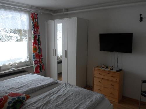 ブラウンラーゲにあるFerienwohnung Ortliebのベッドルーム(ベッド1台、テレビ、ドレッサー付)