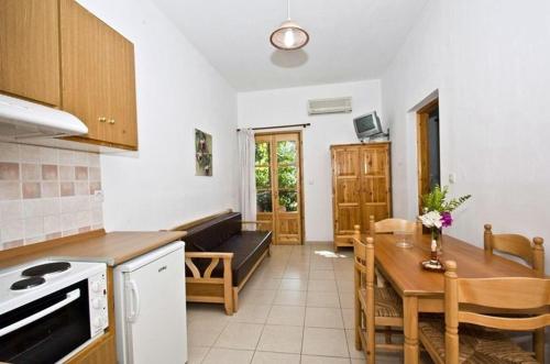 a kitchen and dining room with a table and a kitchen and a dining room at Athina Apartments in Neo Klima