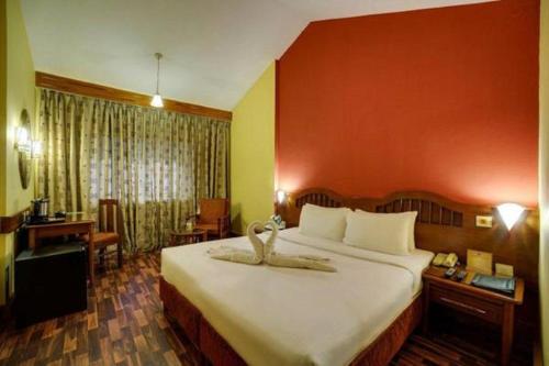 En eller flere senge i et værelse på Ramee Guestline Hotel Bangalore