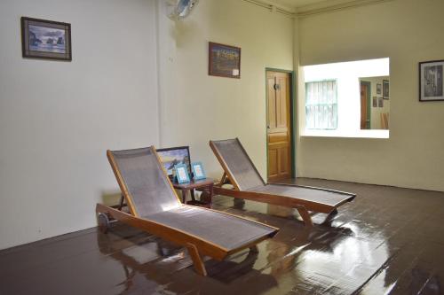 two chairs in a room with a table and a window at Thaweesuk Heritage Homestay in Phangnga