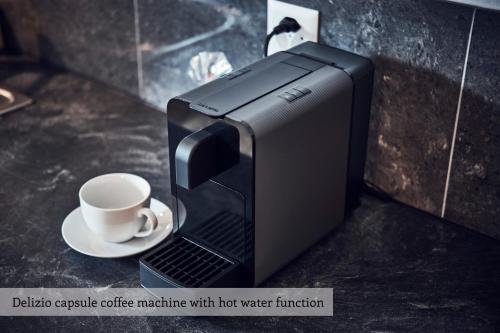 a black coffee machine with a cup on aucer at Serviced Apartments by Solaria in Davos