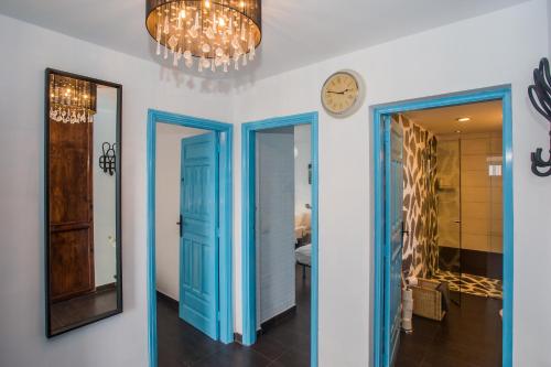 a hallway with blue doors and a clock on the wall at Palm Villa in Puerto del Carmen