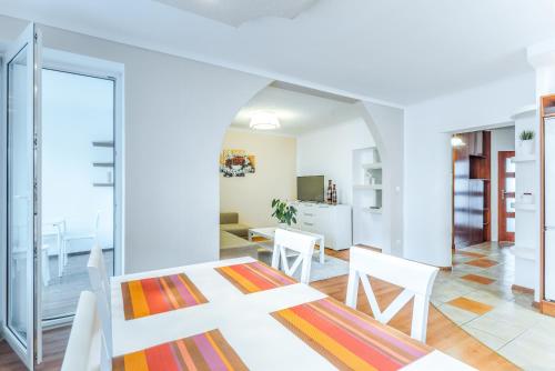a dining room and living room with a table and chairs at Apartament na starowce in Kołobrzeg