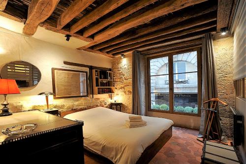 パリにあるHistorical 3 bedroom Gravilliersのベッドルーム1室(ベッド1台、大きな窓付)
