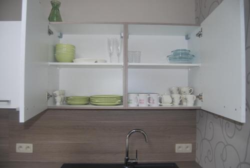 a kitchen with a sink and shelves with dishes at De Reep in Geraardsbergen